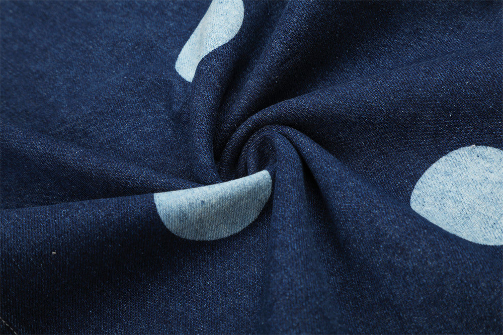 Close-up of dark blue denim fabric with light blue polka dot print