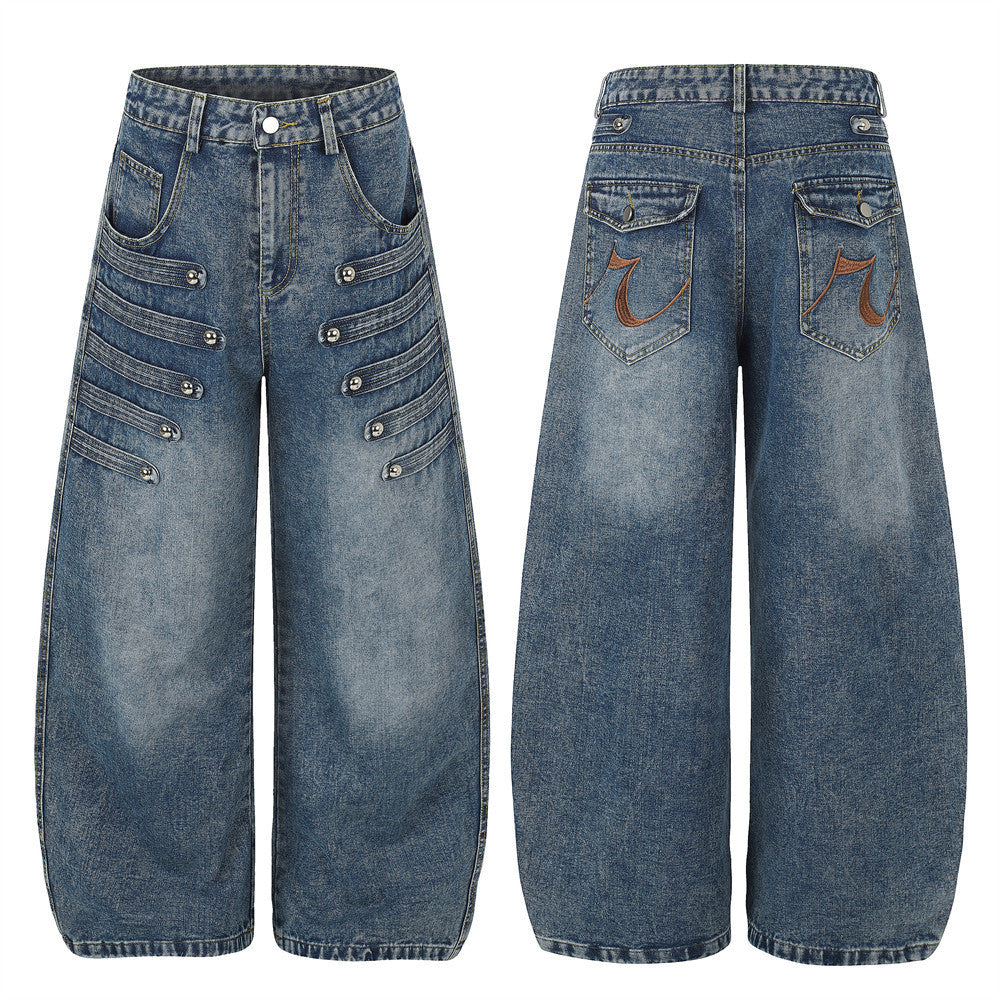 Men's baggy wide-leg distressed blue denim jeans with double-row silver ball stud detail on front thighs and embroidered back