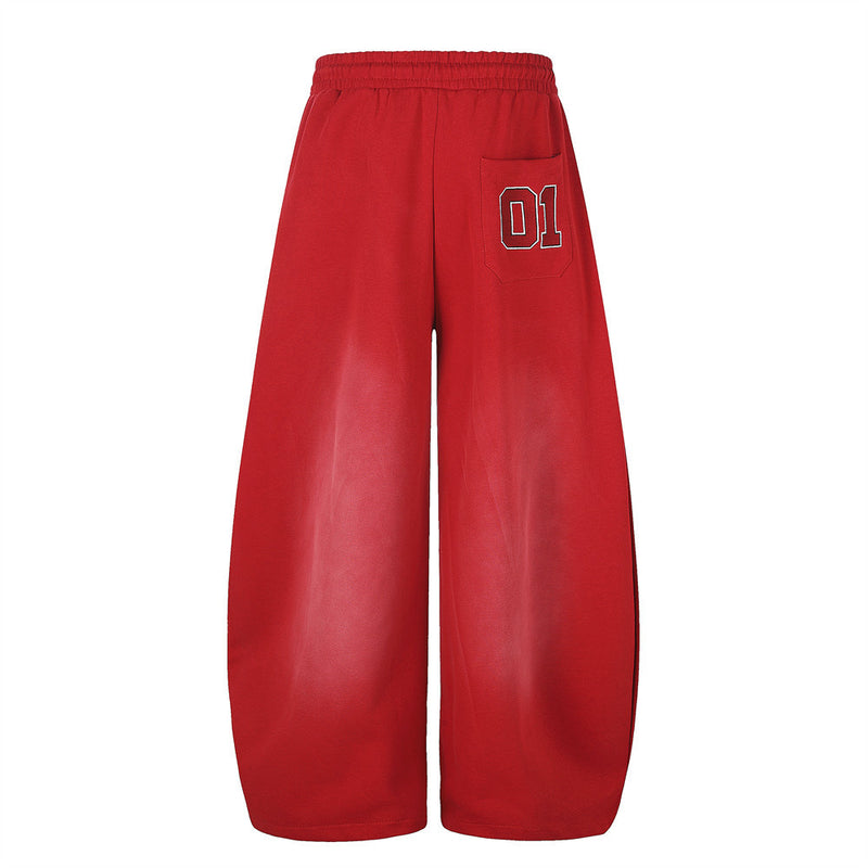 Red wide-leg sweatpants back view with a small 01 patch on the right pocket