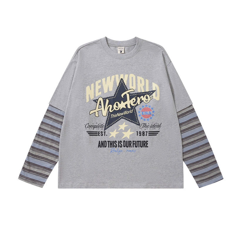 杢グレーのNew Worldレトログラフィック長袖Tシャツ。ブルーのストライプ柄フェイクレイヤード袖をあしらった前面デザイン