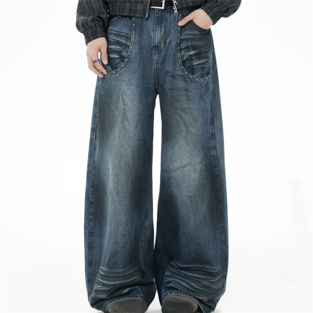Men's wide-leg straight leg jeans in vintage spray-washed blue denim with silver rivet-trimmed curved front pockets and punk