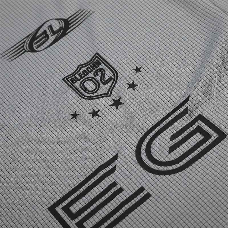 Close-up of gray shirt graphic showing O2 shield logo and large G print