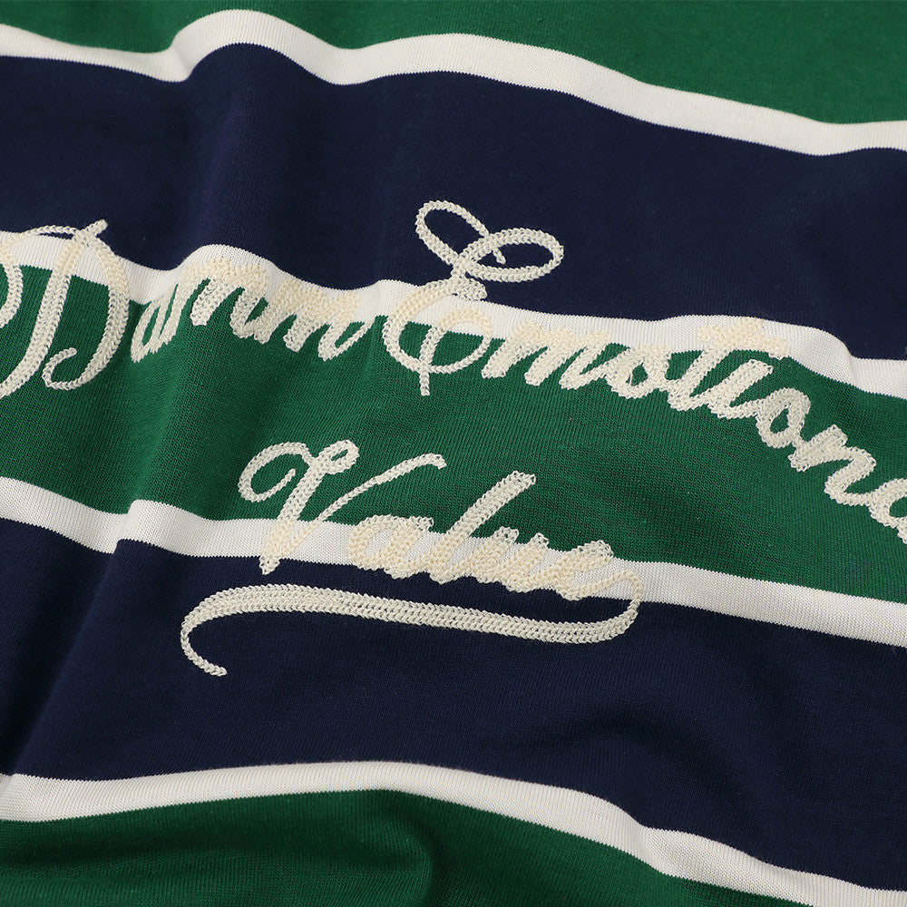 Close-up of embroidered script graphic on green, navy, and white striped shirt