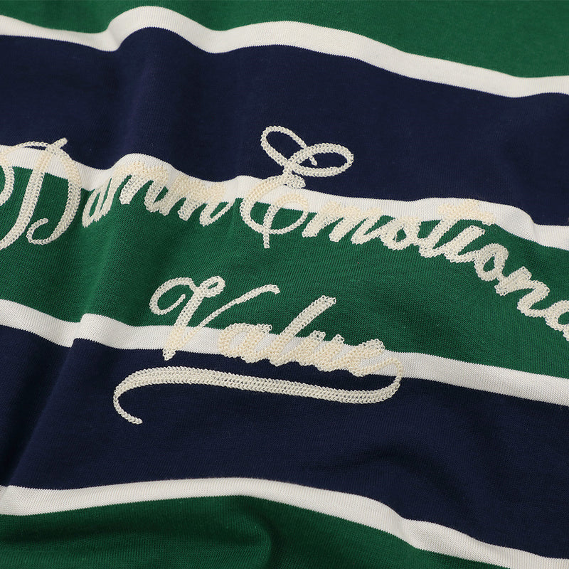 Close-up of embroidered script graphic on green, navy, and white striped shirt