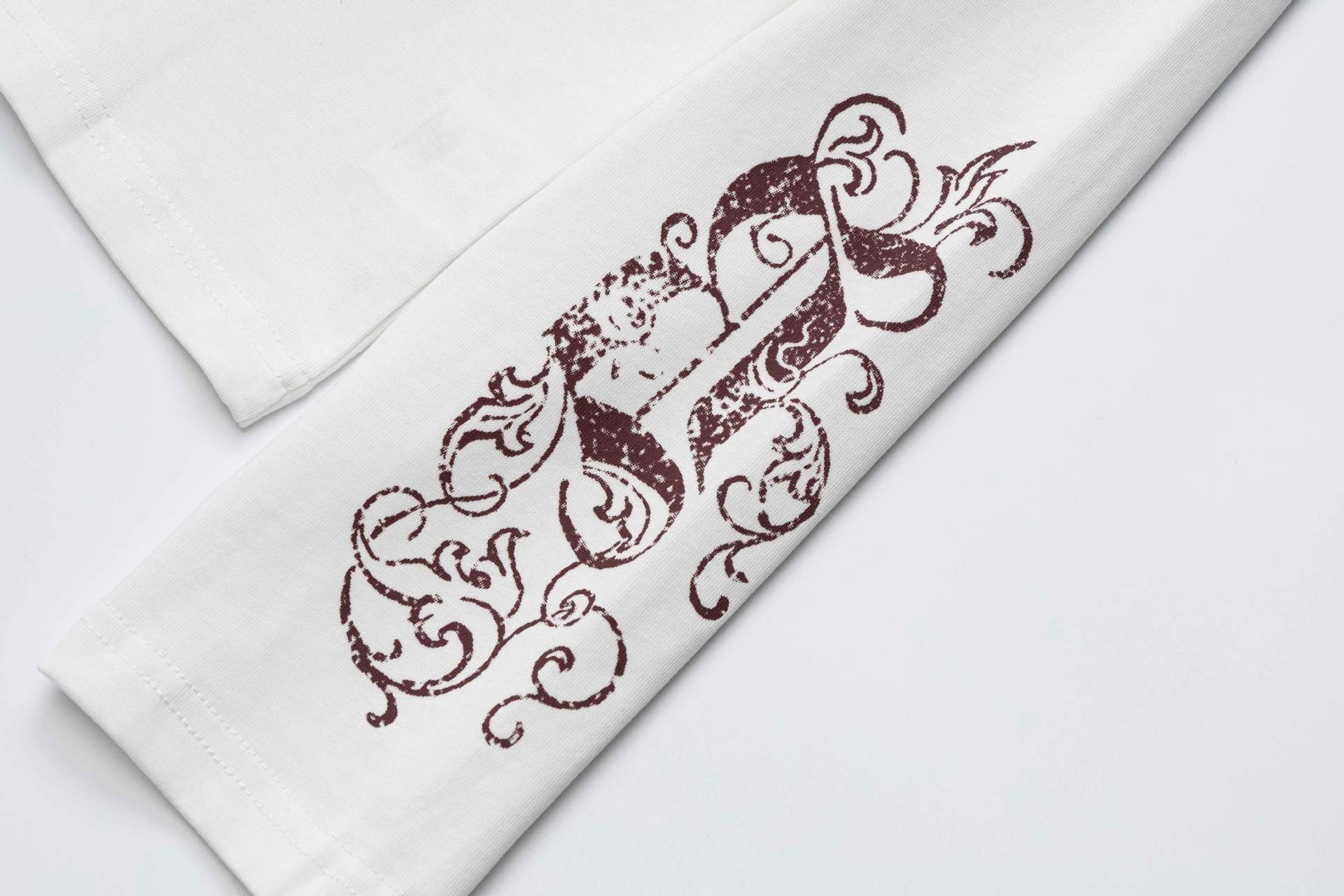 Camiseta de manga larga con cruz de tachuelas y estampado de calaveras en las mangas