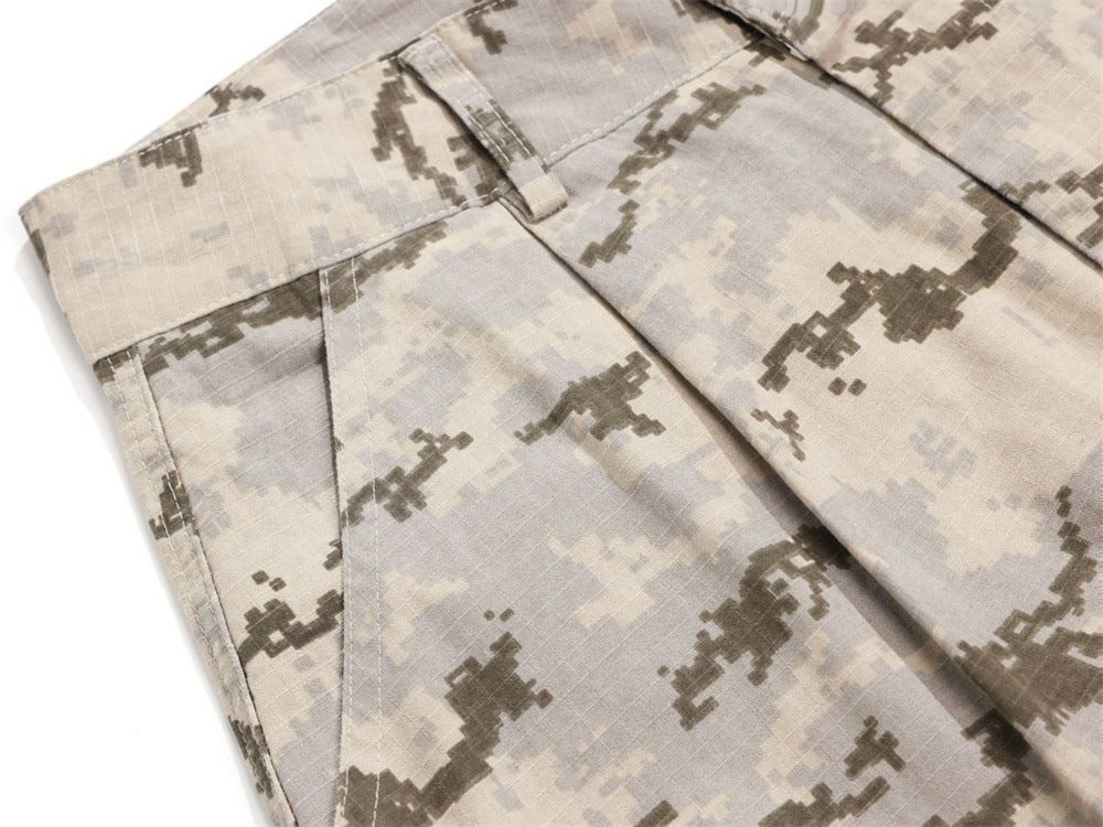 Close-up of desert camo pants front pocket and pleated waistband detail