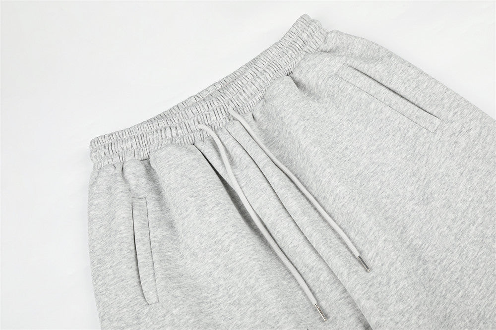 Close-up of gray sweatpants waistband, drawstring, and front pockets