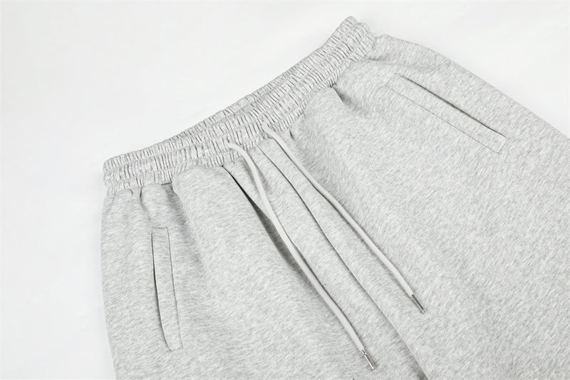 Close-up of gray sweatpants waistband, drawstring, and front pockets