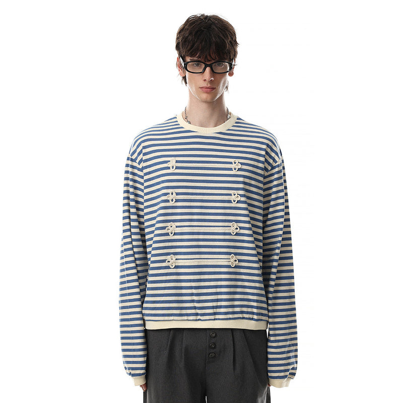 Model wearing blue and cream striped long sleeve shirt with contrast trim and floral knit front