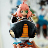 The Spy × Family Anya Forger PVC Figure (15 cm), showcasing her iconic pink hair, cat ears, and green monocle, is seated in a stylish black and orange spherical vehicle as Frieza cosplay. The figure rests gently in someone&