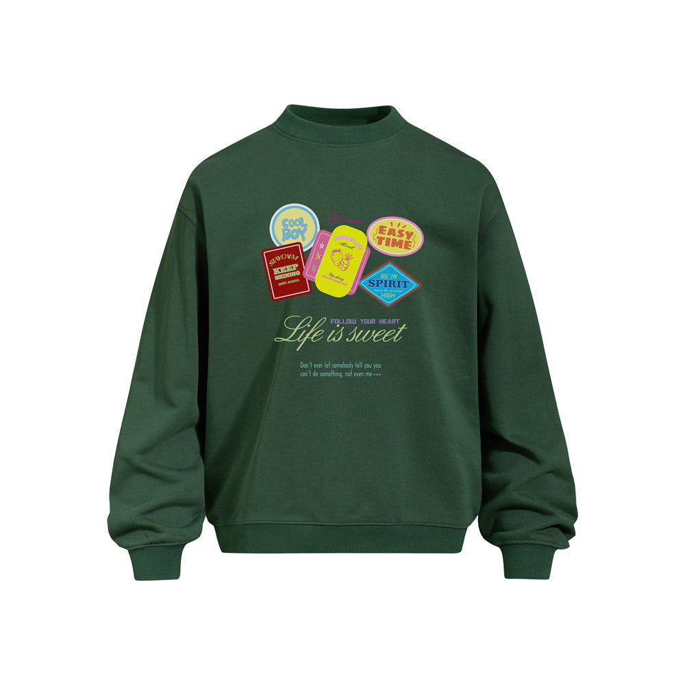 Oversized men's crewneck sweatshirt in forest green with colorful retro sticker badge graphic print reading Life Is Sweet on