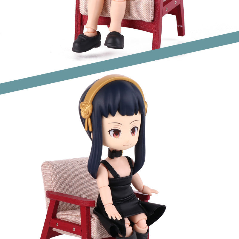 A 13CM Nendoroid from Spy × Family features a figurine with long black hair, a gold headband, and a black outfit seated on a mini red chair. The diagonal split highlights different angles of this poseable anime collectible, part of the Anya &amp; Yor Forger set.