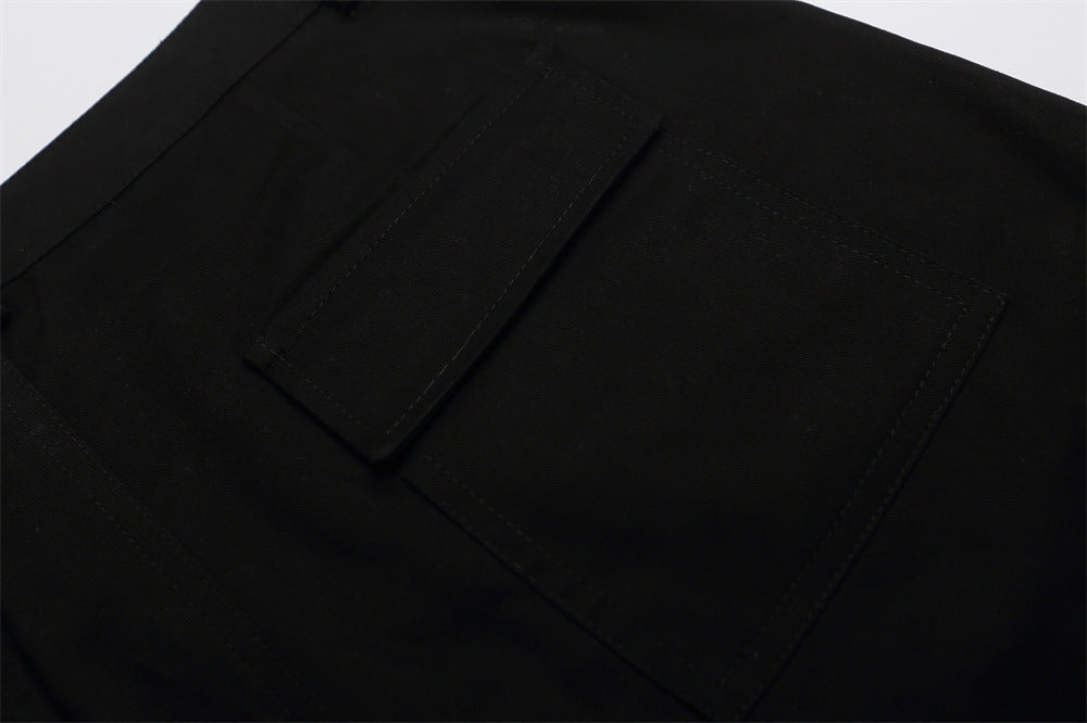Close-up of black shorts back pocket with flap and top-stitched edges