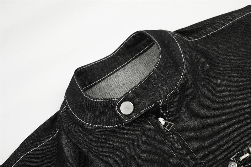 Close-up of black denim jacket stand collar with snap button and front zipper pull