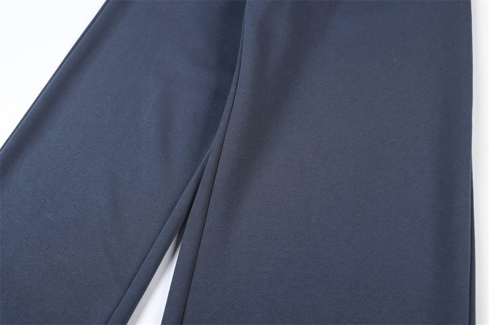 Close-up of navy track pants leg showing smooth wide-leg drape and seam line
