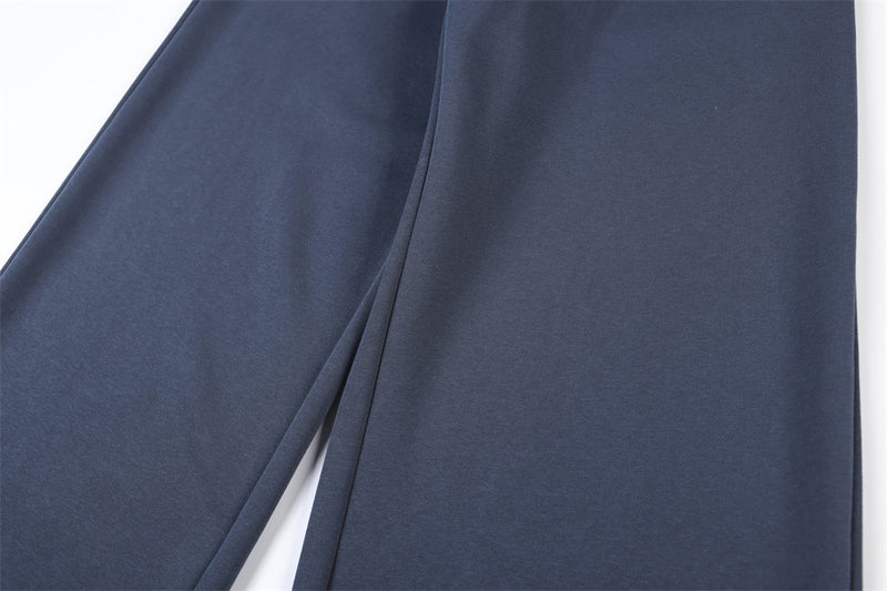 Close-up of navy track pants leg showing smooth wide-leg drape and seam line
