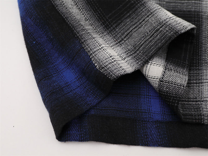 Close-up of hem and sleeve cuff on blue and white plaid shirt
