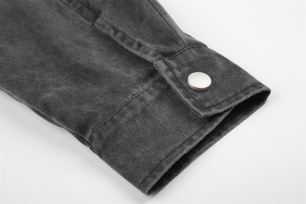 Close-up of black jacket sleeve cuff with snap button and folded hem