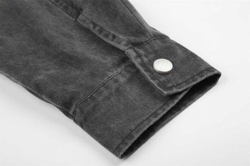 Close-up of black jacket sleeve cuff with snap button and folded hem