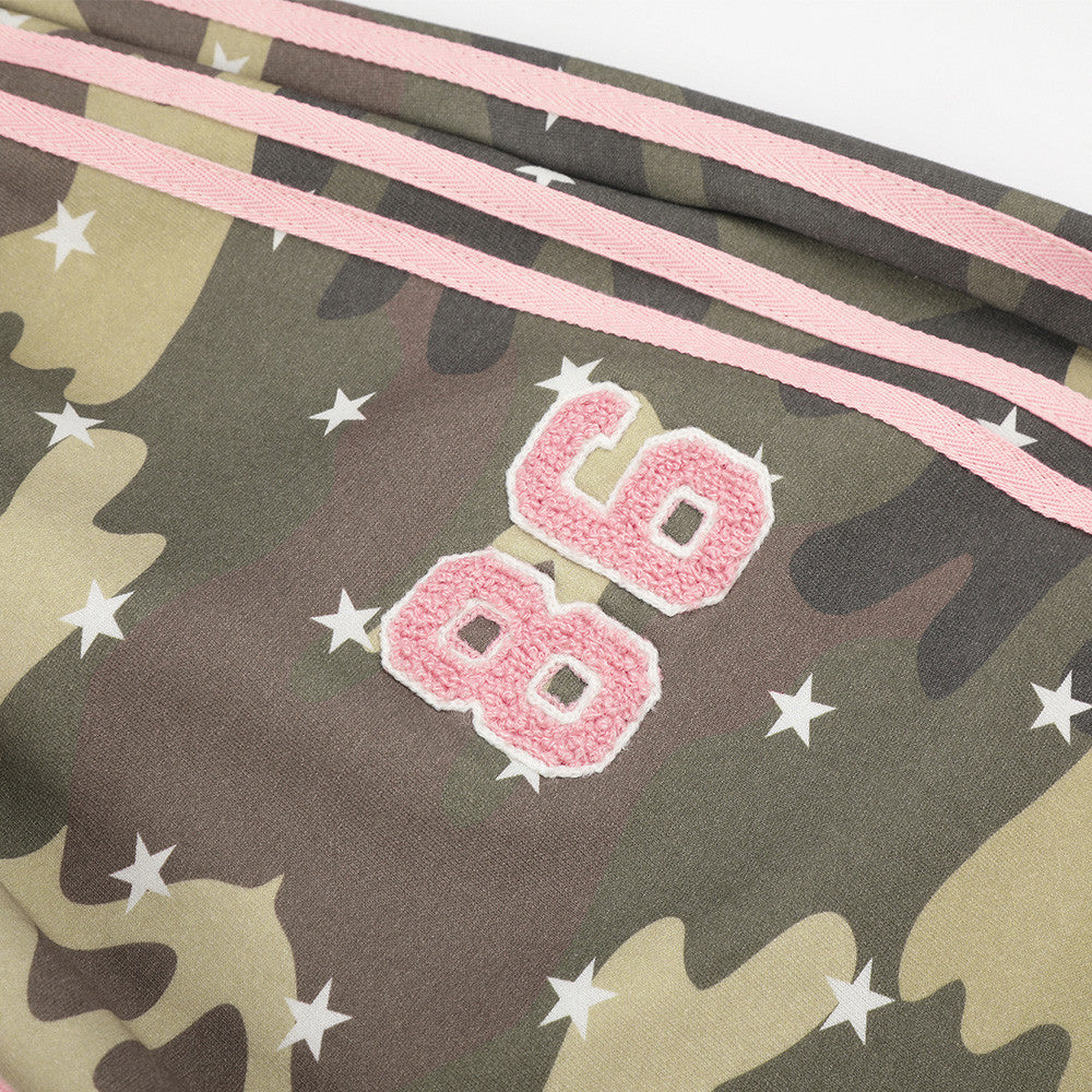Close-up of pink 86 chenille patch on camo pants with side stripes