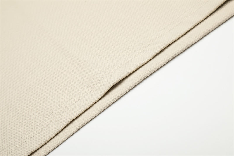 Beige hem detail with textured knit fabric and clean stitched edge