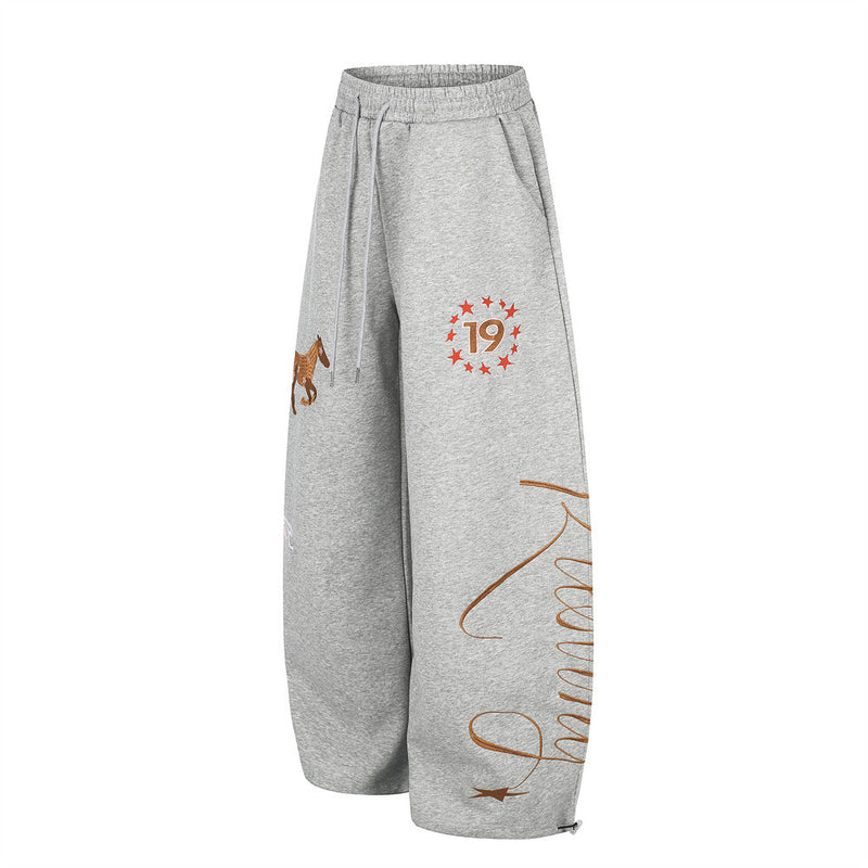 Side view of gray wide-leg sweatpants with horse embroidery, star 19 graphic, and script print