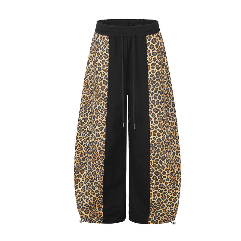 Pantalon de survêtement noir à jambes larges avec empiècements latéraux léopard sur toute la longueur, taille à cordon et bas zippés
