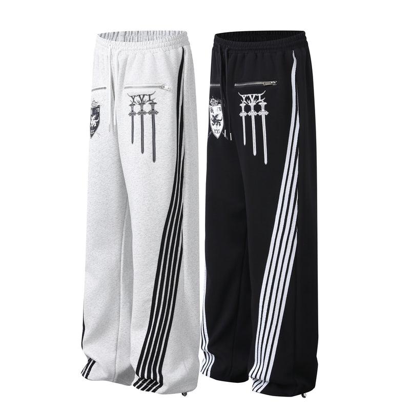 Pantalon de survêtement à jambes larges avec graphisme héraldique et détails latéraux multibandes