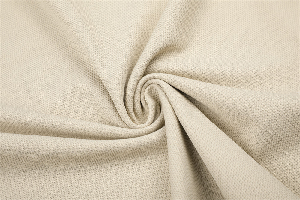 Beige textured fabric close-up with folded drape