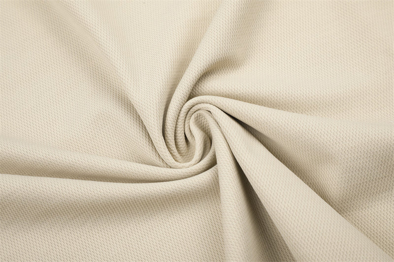Beige textured fabric close-up with folded drape