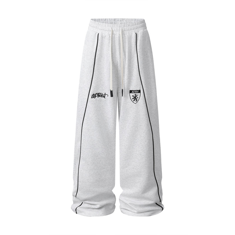 Pantalon de survêtement à jambes larges gris chiné avec passepoil contrastant noir et écusson brodé sur le devant de la cuisse