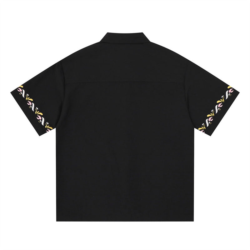 Black short sleeve button-up shirt back view with floral embroidery along both sleeve hems
