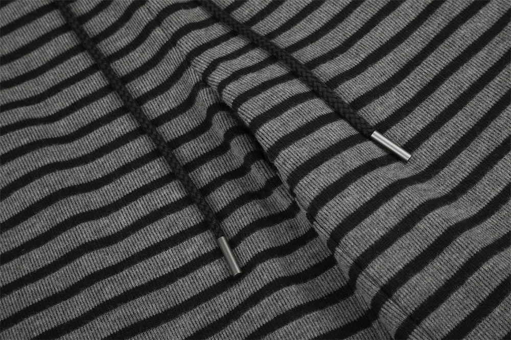 Drawstring ends on black and gray striped knit pants, close-up detail