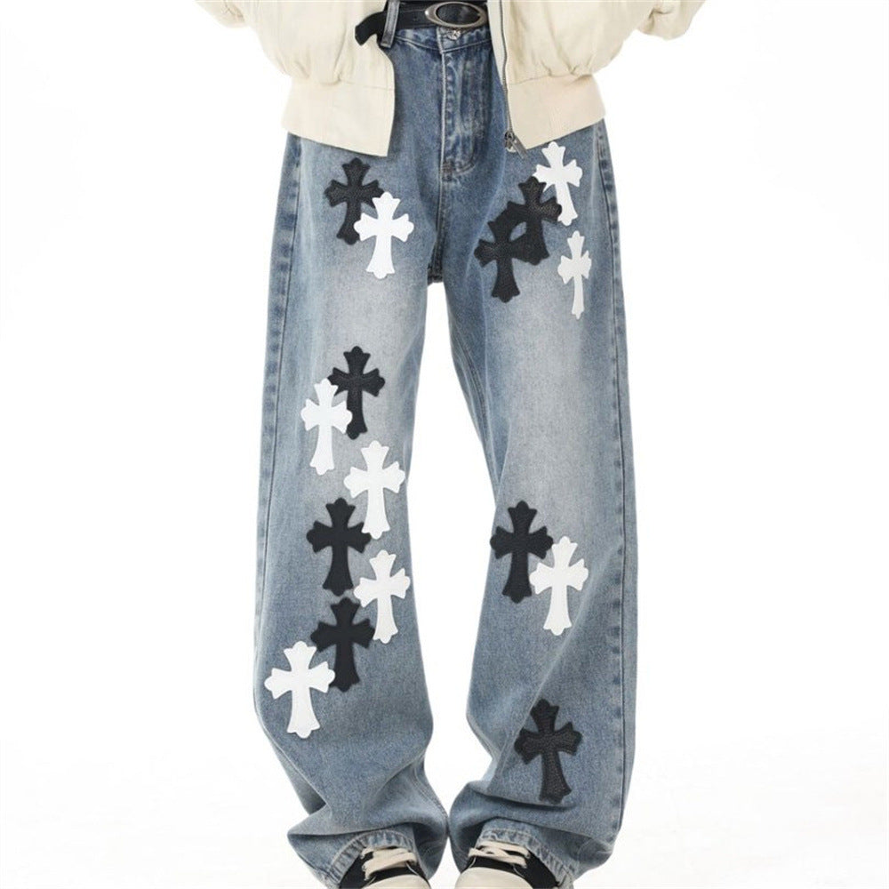 Light blue wide-leg jeans with black and white cross patches, front view on model