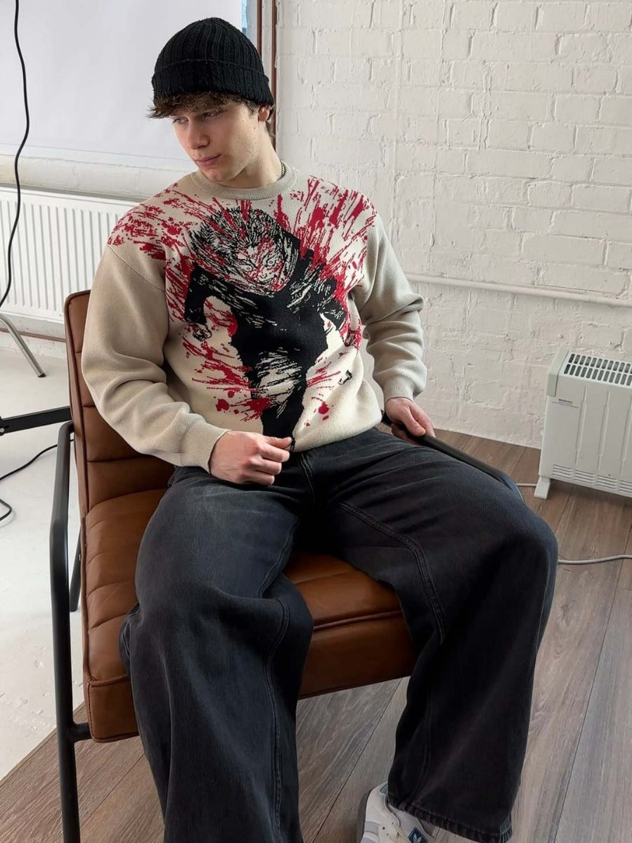 A person is sitting on a brown chair, wearing a black beanie and the Jujutsu Kaisen Premium Yuji Itadori-Inspired Knit Sweater featuring a Bloody Battle Jacquard Design. Their dark wide-legged pants enhance the streetwear aesthetic against a white brick wall and small heater.