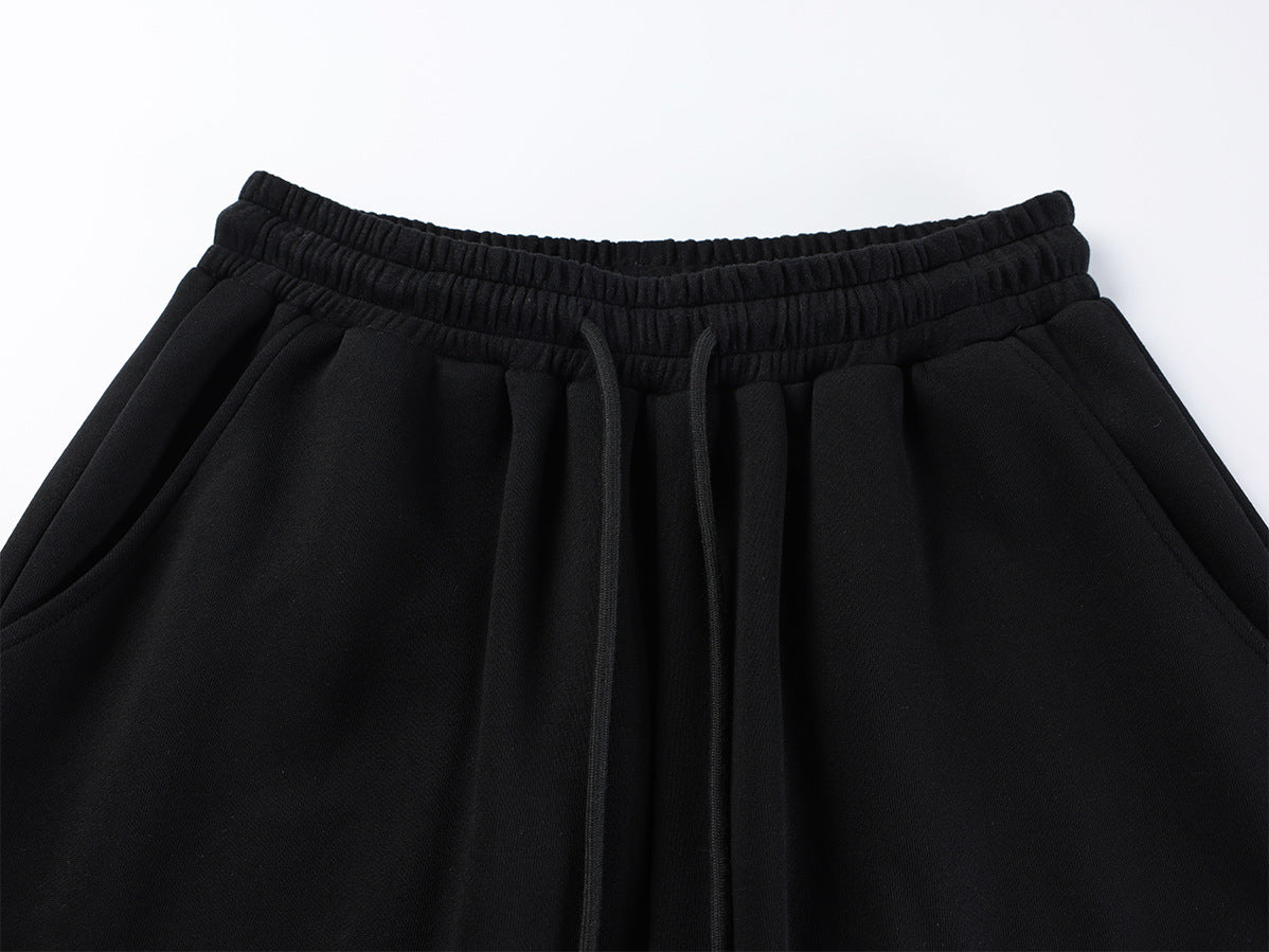 Pantalon de survêtement à jambes larges avec imprimé graffiti cursif orné de rivets