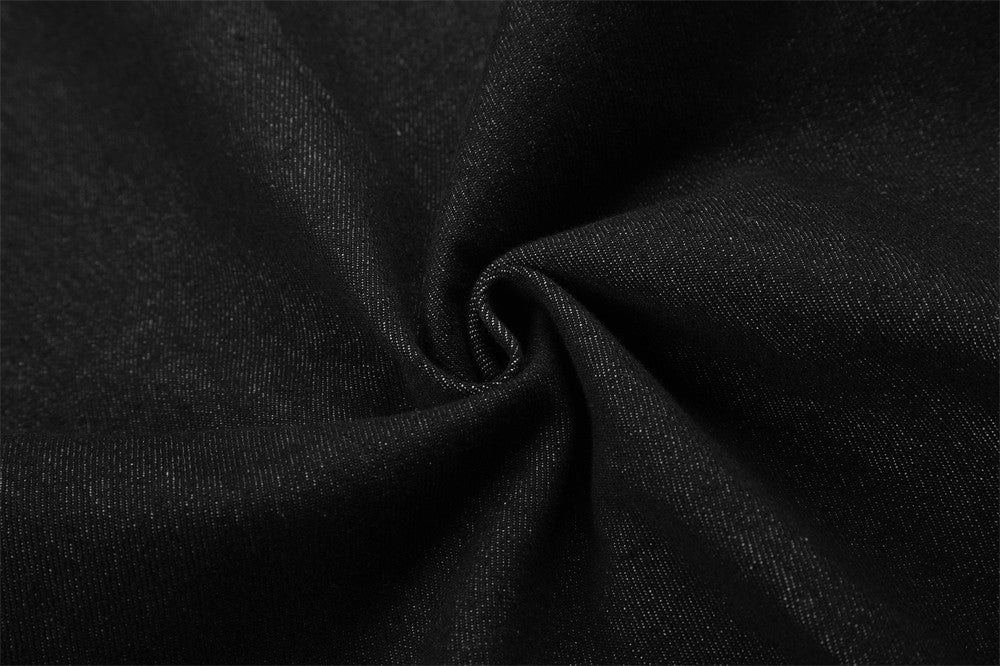 Close-up of black denim fabric texture with gathered fold
