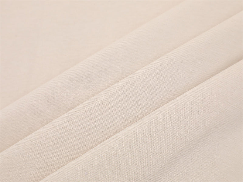 Close-up of cream fabric texture with soft folded drape