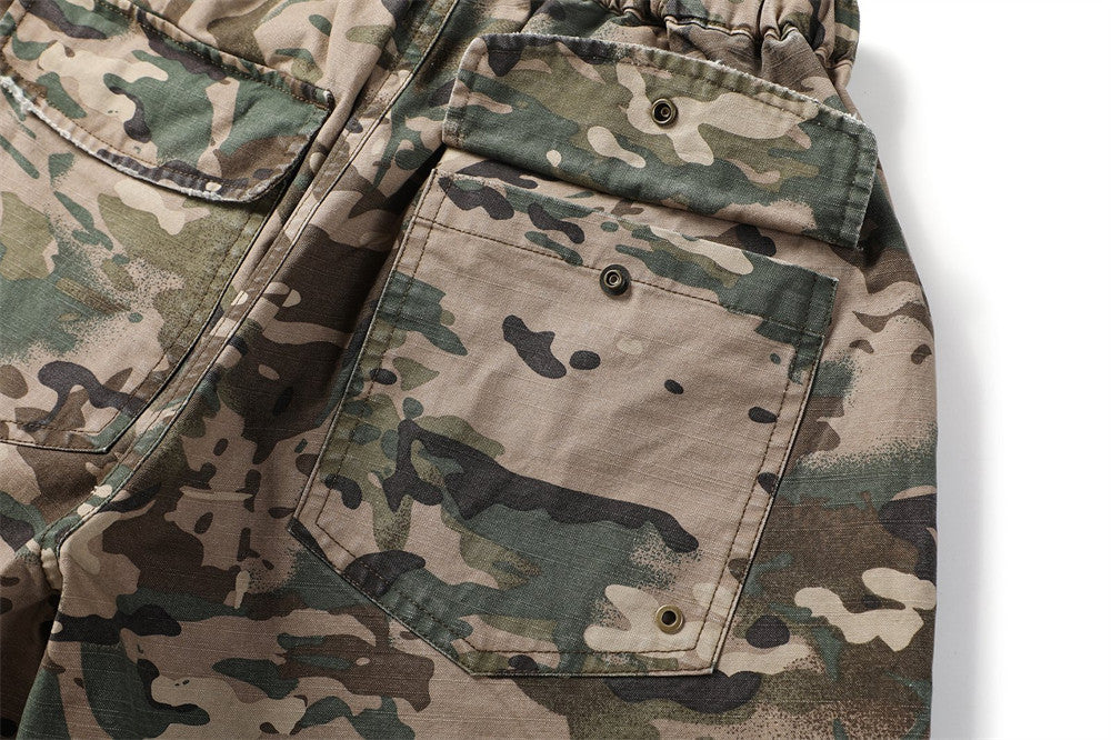 Close-up of back cargo pocket on camouflage shorts with snap flap closure
