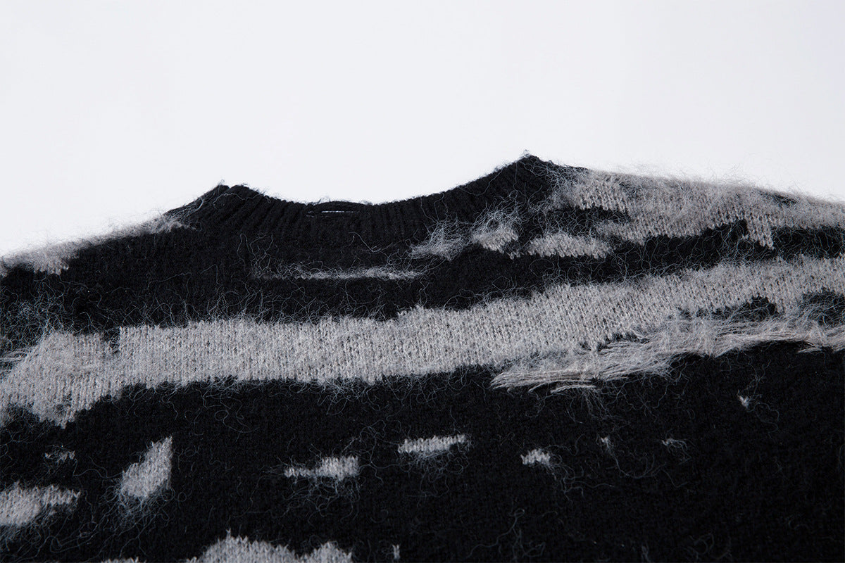 Close-up of the black ribbed crew neckline against the gray and black distressed stripe knit