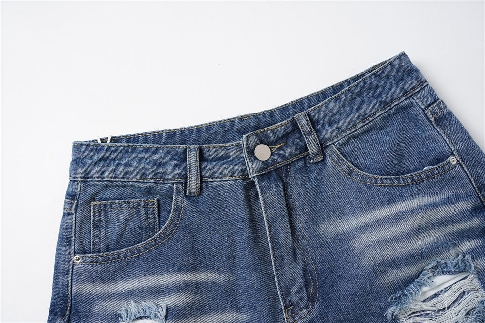 Close-up of blue denim waistband with button closure and front pockets