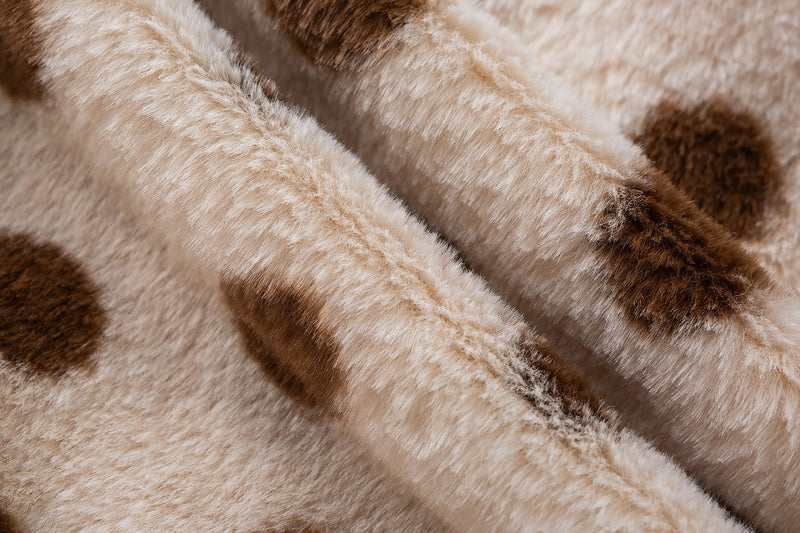 Close-up of the soft cream faux shearling surface and raised brown polka dot texture