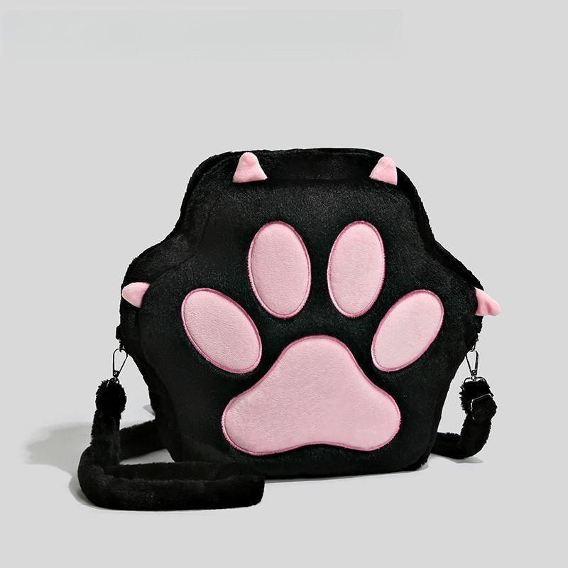 The Adorable Cat Paw Plush Shoulder Bag by Seakoff features a fun original design with 3D pink ears and a soft pink paw print on black plush, complete with an adjustable strap, making it the ideal feline-inspired bag against a light gray background.