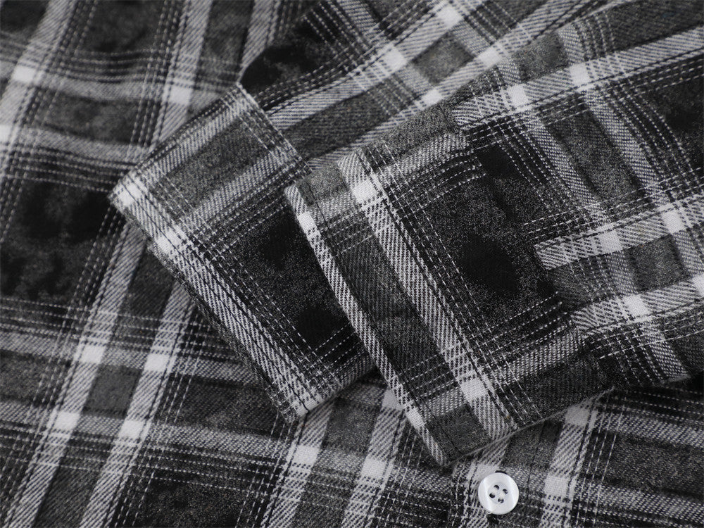 Close-up of black plaid shirt cuff and sleeve seam with white button