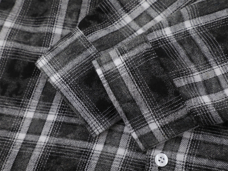 Close-up of black plaid shirt cuff and sleeve seam with white button