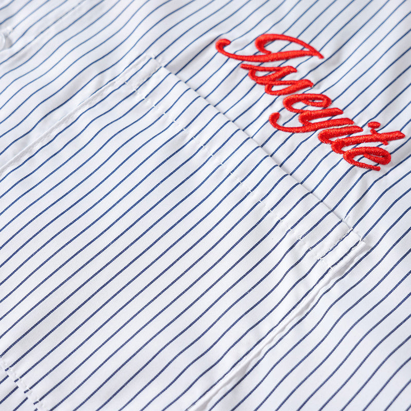 Close-up of red embroidered script on a white shirt chest pocket