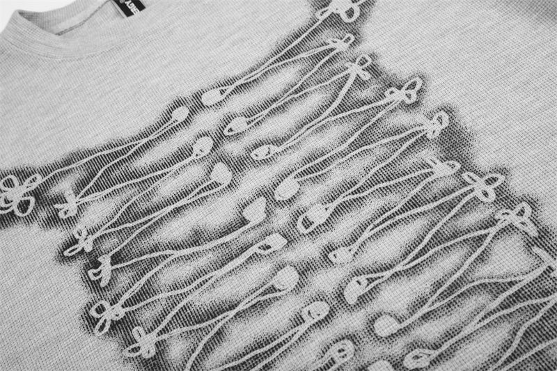 Close-up of gray tee front graphic showing rope-knot lace-up print on textured fabric