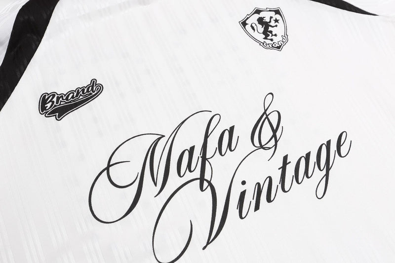 「Mafa & Vintage」の筆記体ロゴ、クレストグラフィック、風合いのある生地が見える、白いジャージー前面のクローズアップ