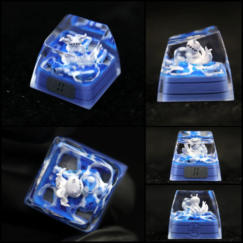 A series of images showcases a custom keycap with a white cartoon shark amid blue waves. Part of the Bijuu collection, this transparent piece highlights intricate aquatic artwork, similar to the Naruto Tailed Beasts keycaps: Kurama, Shukaku, and Saiken for mechanical keyboards.