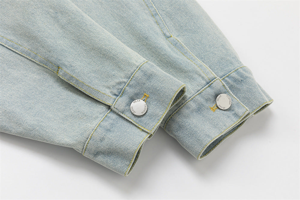 Close-up of the denim jacket sleeve cuffs with stitched tabs and silver-tone buttons